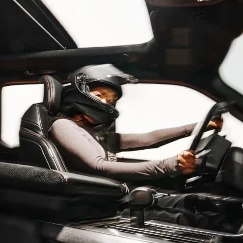 Driver in helmet at the wheel of a Ford Mustang